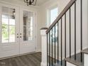 Bright entryway with white double doors and a staircase with black railing at 1809 Bright Lantern Way, Wendell, NC 27591
