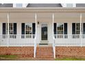 Front entrance with a white porch, brick steps, and black shutters at 2217 Maybrook Dr, Raleigh, NC 27610