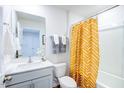 Small bathroom with white vanity, toilet, and yellow shower curtain at 507 Fife Ct, Gibsonville, NC 27249
