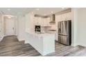 Modern kitchen with white cabinets, stainless steel appliances, and a breakfast bar at 604 Emerald Bay Cir, Raleigh, NC 27610