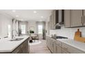 Modern kitchen with gray cabinets, white backsplash, and island at 605 Emerald Bay Cir, Raleigh, NC 27610