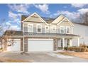 Two-story house with gray siding, stone accents, and a two-car garage at 79 Stallion Way, Benson, NC 27504