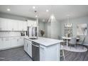 Modern kitchen with white cabinets, quartz countertops, and stainless steel appliances at 393 Fosterton Cottage Way, Raleigh, NC 27603