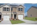 Tan townhome with a two car garage and landscaping at 510 Fife Ct, Gibsonville, NC 27249