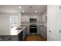 Modern kitchen with gray cabinets, granite countertops, and stainless steel appliances at 511 Fife Ct., Gibsonville, NC 27249