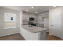 Modern kitchen featuring granite countertops, stainless steel appliances, and gray cabinets at 511 Fife Ct., Gibsonville, NC 27249