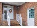 Front entry with brick steps and white railings at 202 S Wilson St, Kenly, NC 27542