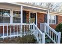 White porch with brick columns and a wreath on the door at 2125 Eveton Ln, Sanford, NC 27330