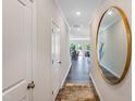 Bright hallway with hardwood floors and a large circular mirror at 278 Paramount Dr, Smithfield, NC 27577