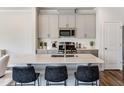 Modern kitchen island with white quartz countertop and black barstools at 278 Paramount Dr # 31, Smithfield, NC 27577