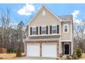 Two-story tan house with two-car garage and stone accents at 316 Bedivere Ln, Durham, NC 27703