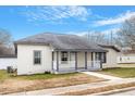 Newly renovated bungalow features a white brick exterior, gray roof, and a covered porch at 115 Kerr Dr, Roxboro, NC 27573