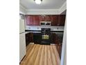 Kitchen with dark wood cabinets, granite counters, and appliances at 7030 Longstreet Dr # A, Raleigh, NC 27615