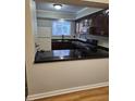 Kitchen features dark wood cabinets and a granite breakfast bar at 7030 Longstreet Dr # A, Raleigh, NC 27615