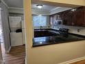 Galley kitchen with dark wood cabinets and granite countertops at 7030 Longstreet Dr # A, Raleigh, NC 27615