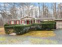 Tan mobile home with red shutters and a well-manicured yard at 1705 Old Nc 10 Hwy, Hillsborough, NC 27278