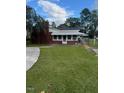 View of the brick house from the side yard, showing a carport at 209 N Watauga Ave, Dunn, NC 28334