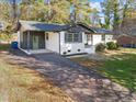 Front view of a charming ranch house with a green door and long driveway at 2124 N Hills Dr, Raleigh, NC 27612