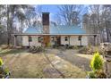 Charming white farmhouse with a green metal roof and stone accents, nestled in the woods at 540 Patterson Dr, Chapel Hill, NC 27516