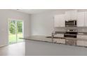 Kitchen with granite countertops, white cabinets, and a view to the backyard at 900 Rhino Bnd, Oxford, NC 27565