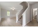 Open staircase with carpet runner and light-colored hardwood floors at 900 Rhino Bnd, Oxford, NC 27565