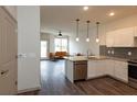 Modern kitchen with white cabinets, granite countertops, and stainless steel appliances at 2202 Gathering Square Ct, Fuquay Varina, NC 27526