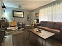 Spacious living room with hardwood floors, a brown leather couch and coffee table, and ample natural light at 807 W Trinity Ave # 241, Durham, NC 27701
