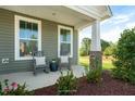 Relaxing front porch with rocking chairs, stone pillars, and landscaping at 1833 Ballard Rd # Clayton Craftsman, Fuquay Varina, NC 27526