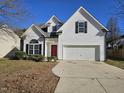 Two-story house with white siding, red door, and attached garage at 104 Annotto Bay Ln, Garner, NC 27529