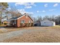 Brick house with detached garage and gravel driveway at 1261 N Nc 49, Burlington, NC 27217