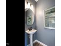 Small powder room with pedestal sink and round mirror at 65 Vili Dr, Broadway, NC 27505