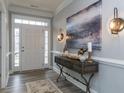 Bright entryway with white door, hardwood floors, and decorative console table at 817 Heartpine Dr, Mebane, NC 27302
