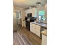Kitchen with white cabinets, stainless steel appliances, and vinyl flooring at 7055 Old Plantation Dr, Graham, NC 27253