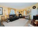 Living room with yellow walls, leather furniture, and hardwood floors at 4941 Rumley Rd, Graham, NC 27253