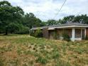 Brick ranch house with overgrown yard at 899 Pittman Ln, Micro, NC 27555