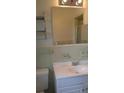 Bathroom with light green tiled walls and a white vanity at 1133 Evans Rd, Cary, NC 27513