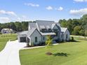 Modern farmhouse with metal roof and stone accents at 8917 Grand Highland Way, Wake Forest, NC 27587