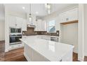 Modern kitchen with white cabinets, quartz countertops, and stainless steel appliances at 2269 Abbeyhill Dr # 133, Raleigh, NC 27610