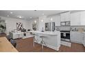 Open concept kitchen features an island, stainless steel appliances, and hardwood floors at Tbd Channel Drop Dr # 123, Clayton, NC 27520