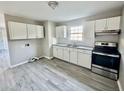 Updated kitchen with white cabinets, granite countertops, and stainless steel appliances at 1304 Queen Ann St, Burlington, NC 27217