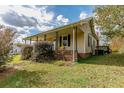 Ranch house with a covered porch, brick base, and yellow chairs at 1054 George Bason Rd, Graham, NC 27253