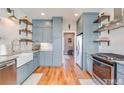 Modern kitchen with light blue cabinets, white subway tile, and farmhouse sink at 255 Baptist Grove Rd, Fuquay Varina, NC 27526