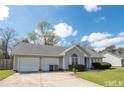Ranch style home with a three-car garage and well-maintained lawn at 60 Rock Harbor Ln, Spring Lake, NC 28390
