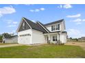 Two-story house with gray and white siding, two-car garage, and a landscaped lawn at 53 Hillwood Dr, Sanford, NC 27332