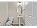 Small powder room with pedestal sink and oval mirror at 147 Hillwood Dr, Sanford, NC 27332