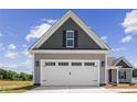 Two-car garage with white doors and gray and brown siding at 50 Oleander Ln, Sanford, NC 27332