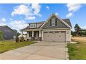 Two-story house featuring a gray and beige exterior, two-car garage, and landscaping at 127 Hillwood Dr, Sanford, NC 27332