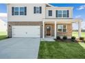 Two-story home with brick and siding exterior, attached garage, and landscaping at 77 Finsbury Ct, Lillington, NC 27546