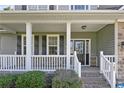 Covered front porch with white railings and brick steps leading to the front door at 157 Regimental Dr, Cameron, NC 28326