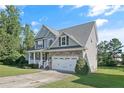 Two story house with gray siding, stone accents and a two car garage at 157 Regimental Dr, Cameron, NC 28326